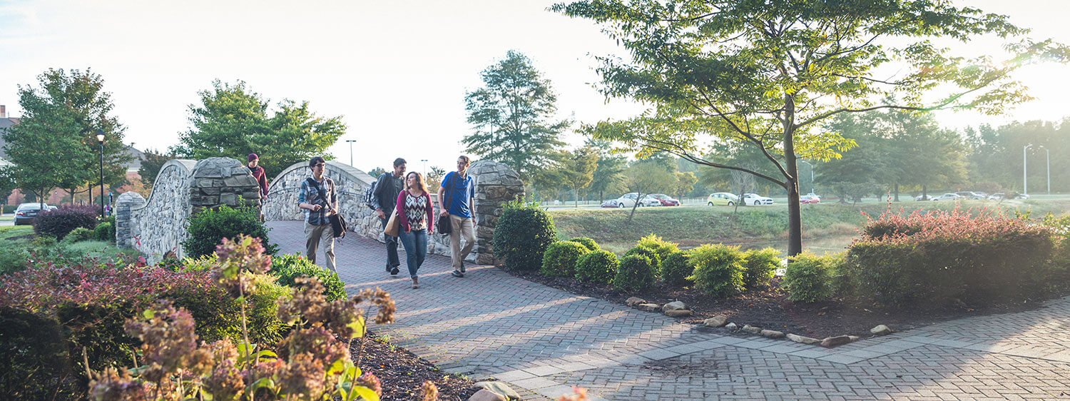 Students walk across the bridge that connects Regent University with undergraduate student housing.