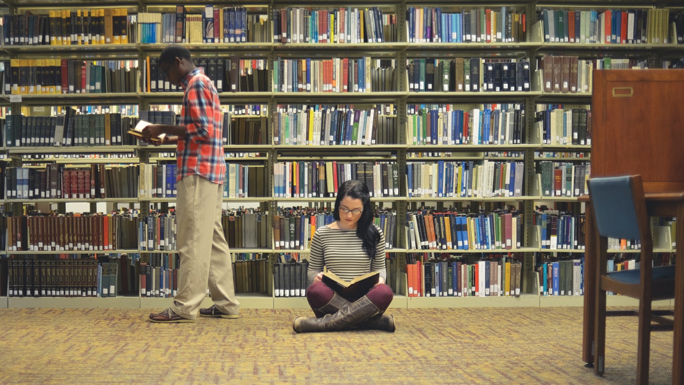 Students at the Regent University library: Learn about tuition rates for transfer students.