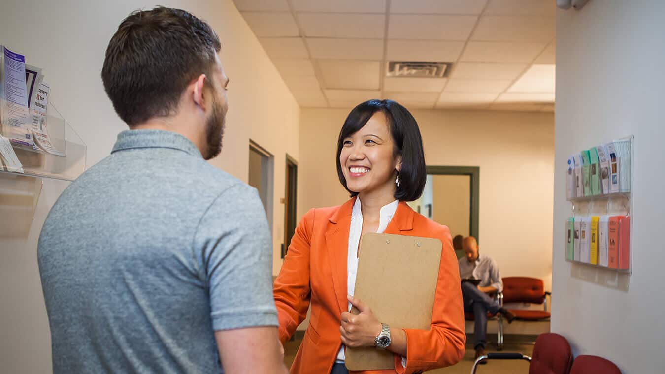 A professor greets a visitor at Regent, a university that offers a clinical mental health counseling program.