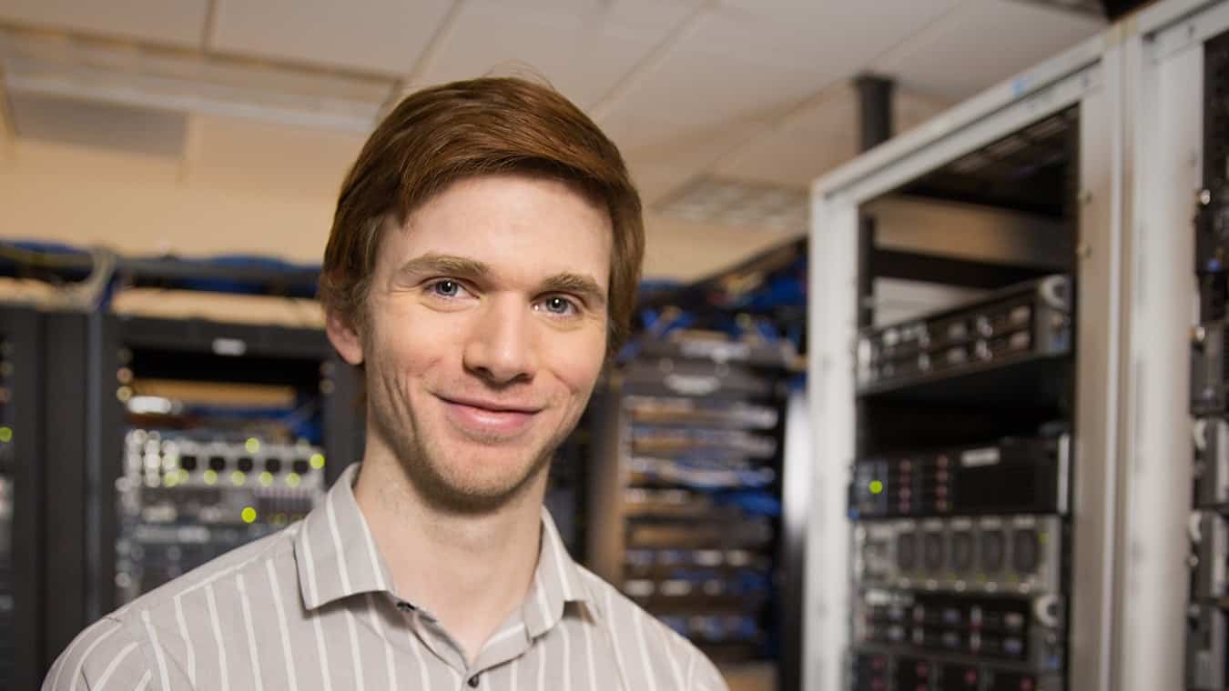 A person in a server room: Pursue a CISCO Networking online at Regent University.