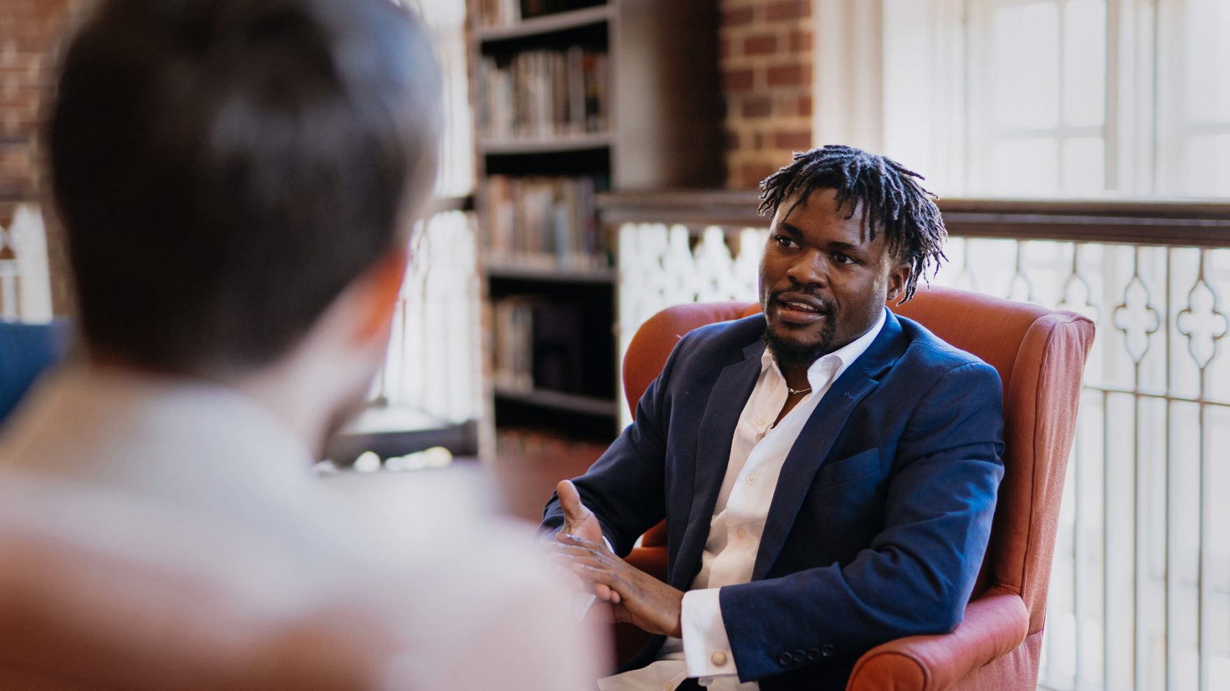 Regent University counseling student speaking with another student in Regent University's Law Library located in Virginia Beach, Virginia.