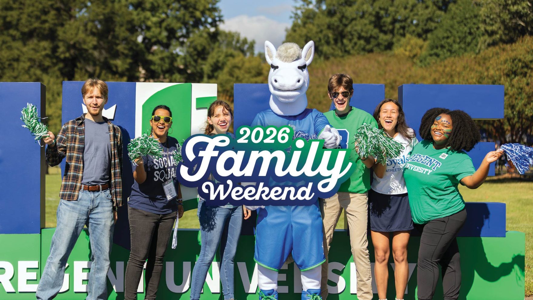Regent University students and mascot Royal the Royal celebrate 2026 Family Weekend, posing in front of large Regent University block letters on the campus lawn