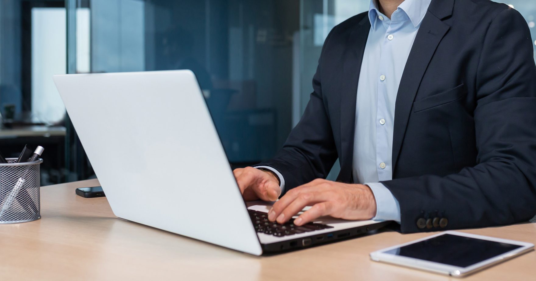 Regent University law student typing on laptop on campus in Virginia Beach, Virginia.