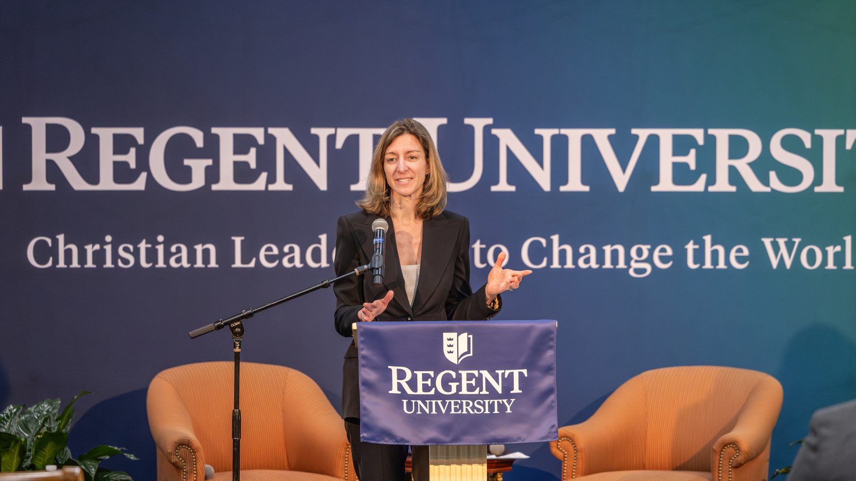 Former Congresswoman Elaine Luria speaking on the podium at an event hosted in Robertson Hall at Regent University's campus in Virginia Beach, Virginia.