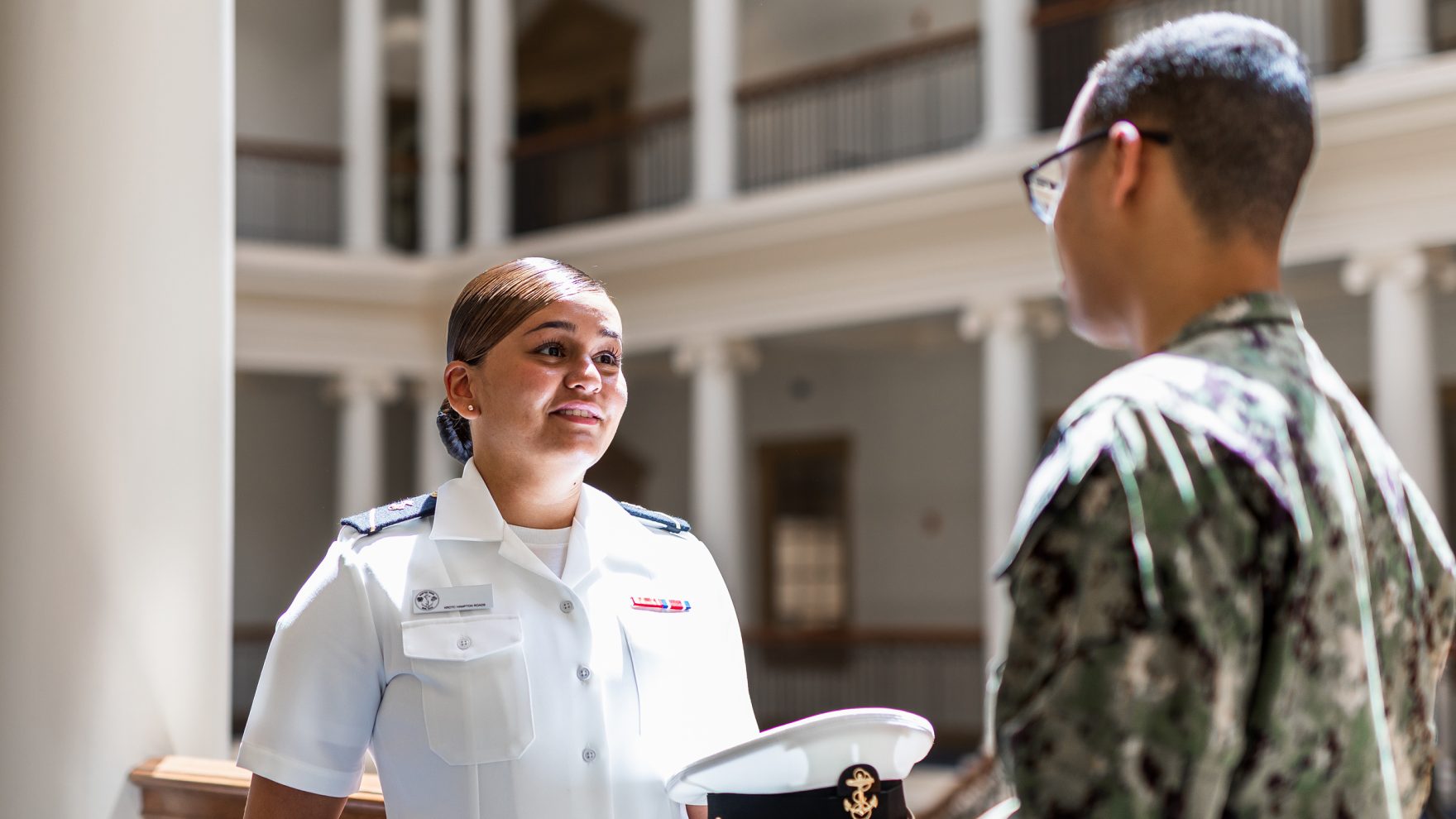 Two military students speaking in Robertson Hall at Regent University campus, located in Virginia Beach, Virginia.
