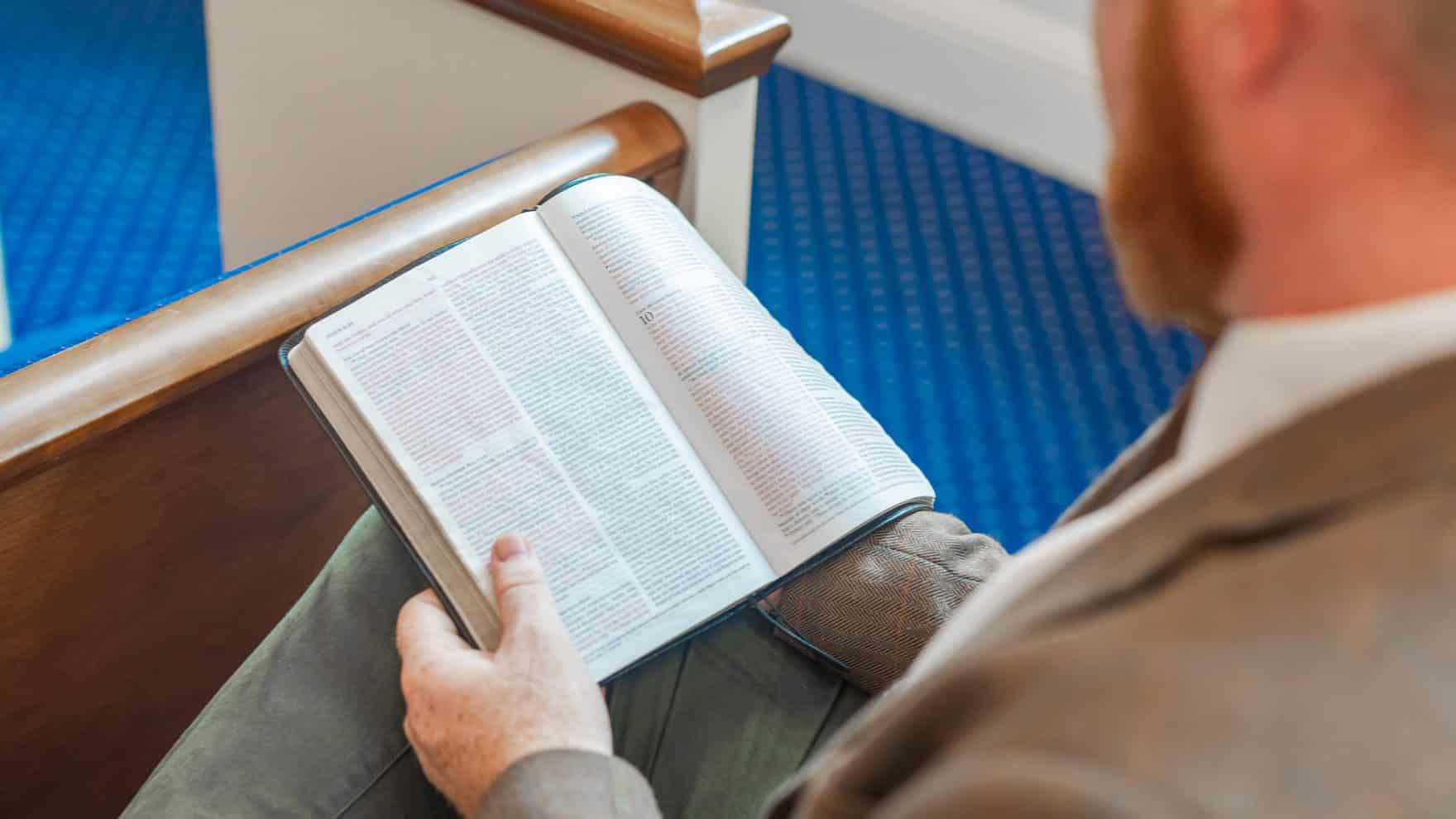A man reading his Bible during a church service.