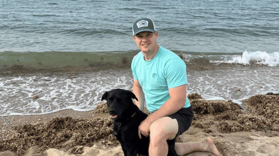 Seth French and his Black Labrador Donnie at the ocean in Virginia Beach